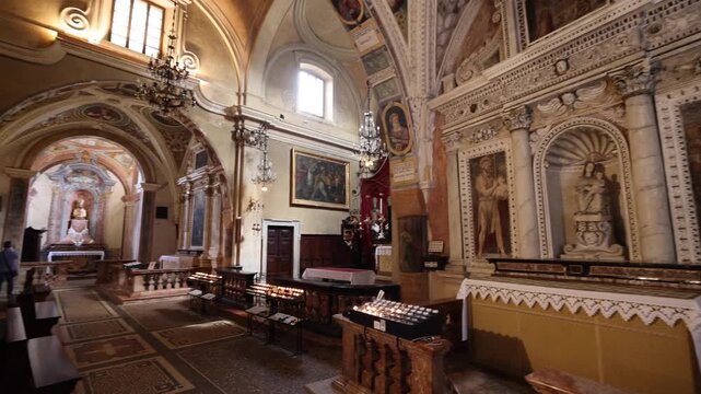 View of the ornate altar and religious frescoes inside the historic Church of Santa Maria del Sasso in Morcote, Ticino, Switzerland.