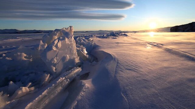 View of Lake Baikal ice formations at sunset with golden light reflecting on the frozen surface in Khuzhir, Irkutsk Oblast, Russia.