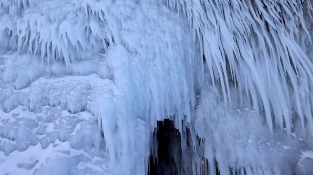 View of massive icicles hanging from the rocky entrance of an ice cave at Lake Baikal in Khuzhir, Irkutsk Oblast, Russia.