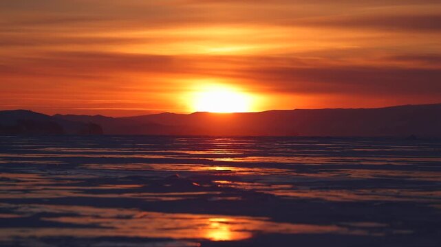 View of sunset over Lake Baikal with golden light reflecting on the water surface in Khuzhir, Irkutsk Oblast, Russia.