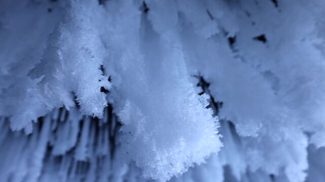 View of intricate ice formations and frost clinging to the rocky cliffs of Lake Baikal in Khuzhir, Irkutsk Oblast, Russia.