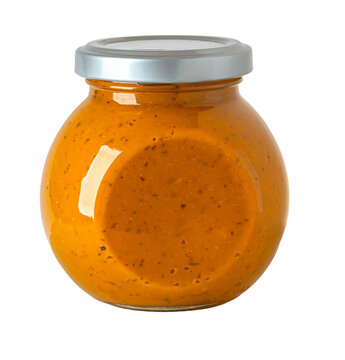 Glass jar of orange pesto sauce on transparent background