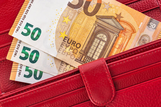 Macro close up of fifty euro banknotes inside red leather wallet
