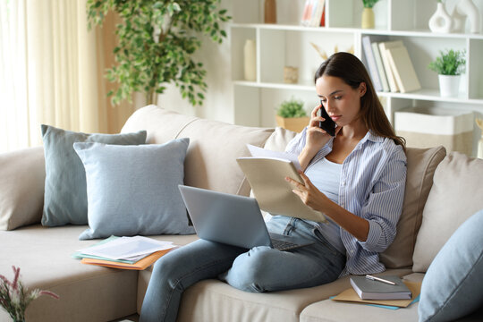Telecommuter talking on phone and checking documents