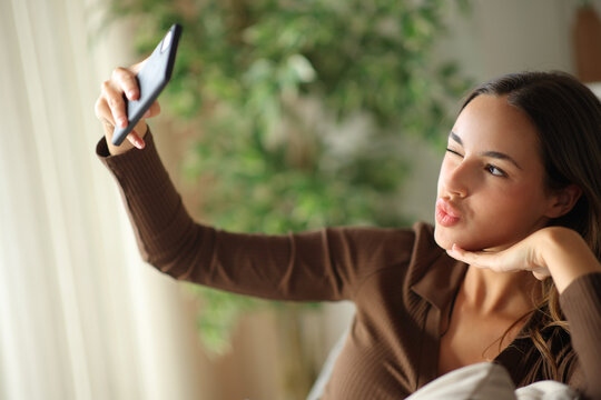 Woman doing selfie with smart phone at home