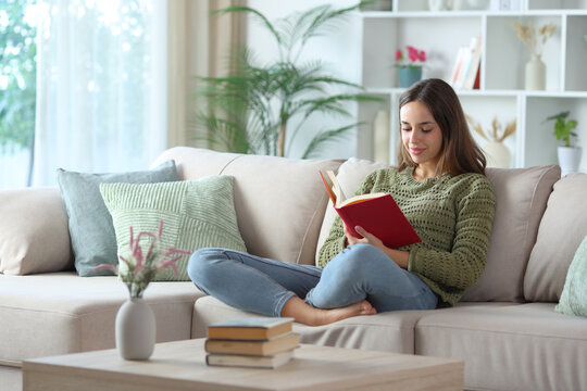 Satisfied woman in green reading red book