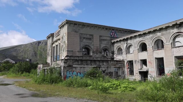 View of an abandoned building with weathered facade and graffiti in Kirovsk, Murmansk Oblast, Russia.