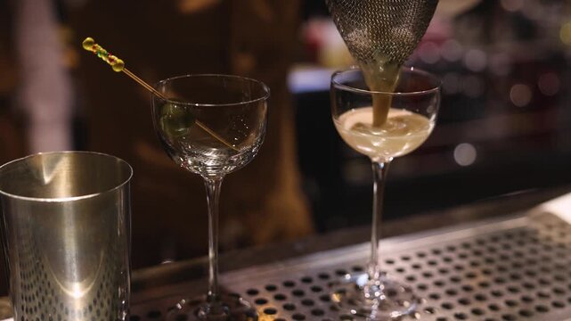 Bartender working, beautiful row line of different coloured liquor alcohol cocktails on a party in a bar, catering banquet on event, barman mixing drinks, selection of beverages in a restaurant club