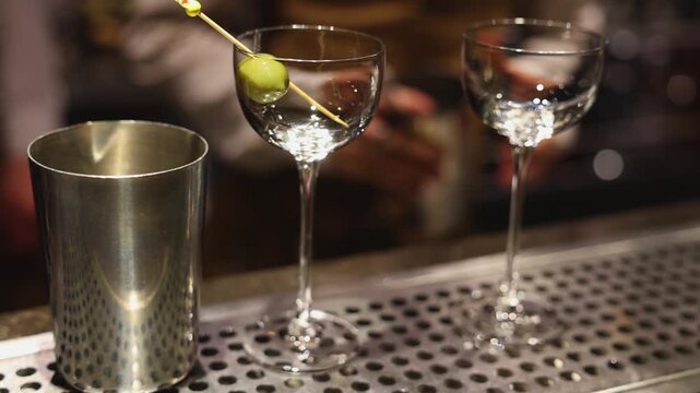 Bartender working, beautiful row line of different coloured liquor alcohol cocktails on a party in a bar, catering banquet on event, barman mixing drinks, selection of beverages in a restaurant club