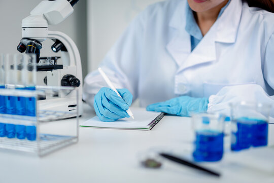 Scientist researcher hands documenting experiment observations i
