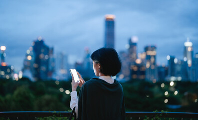 Business asian woman relax using smartphone social network communication metropolis city building background