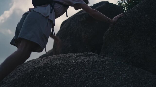 Man hiking up steep rocks in Koh Phangan Thailand