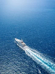 Aerial view of an ultra modern luxury yacht cruising over sparkling ocean with speed © moofushi