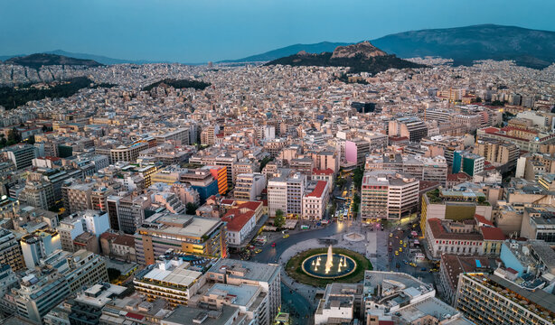 Panoramic aerial view of the skyline of central Athens, Greece, with Omonia square and Lycabettus Hill in the background during dusk