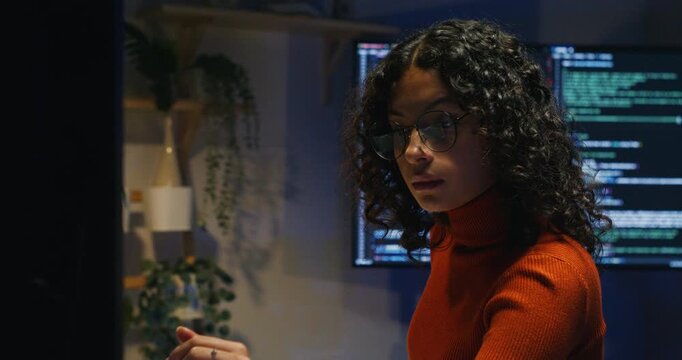 Latin woman triages a cybersecurity alert in a dim ops room, isolating affected services and notifying stakeholders.