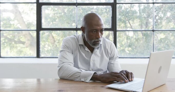 Lifestyle videos indoor of people doing activities at office, working on laptop, man in white shirt
