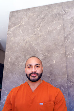 Male beautician standing at beauty salon reception, offering professional service and customer care