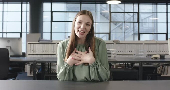 Close up of people talking to the camera, smiling woman sitting at office desk