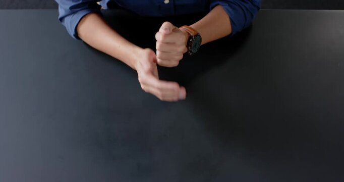 Close up of people talking to the camera, gesturing with hands, person in blue shirt sitting at blac