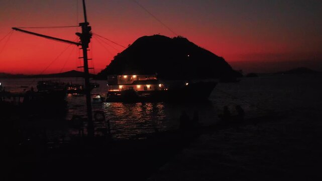 View of a boat silhouetted against the vibrant sunset sky near Pulau Kalong Rinca in Komodo, East Nusa Tenggara, Indonesia.