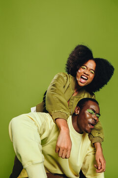 Friends share a piggyback dance and singing moment in the studio with laughter and trust