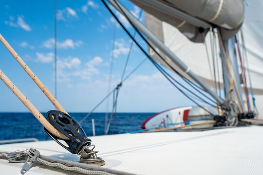 Sailboat deck hardware with rope and pulley under sail. Yacht rigging and sailing equipment during navigation at sea.