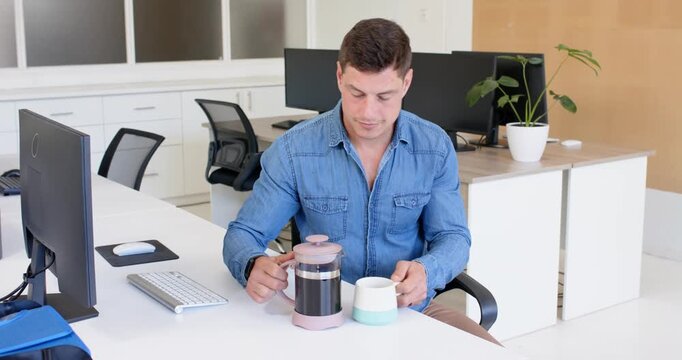 Lifestyle videos indoor of people doing activities at office, man in denim shirt sitting at desk in