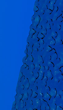 Blue building facade with curved glass shapes and wavy design pattern