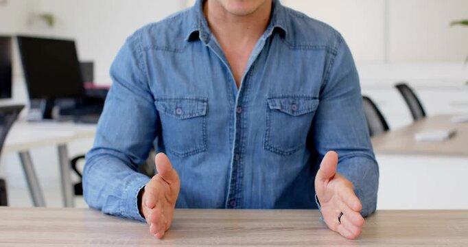 Close up of people talking to the camera, sitting at desk, man in denim shirt clasping hands, ready