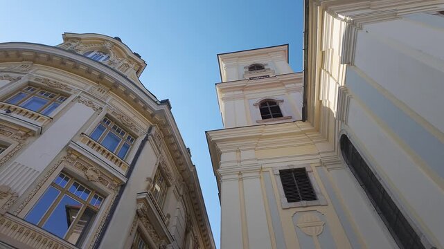 Holy Trinity Roman Catholic Church and Sibiu City Hall viewed from below in Piata Mare Sibiu Romania