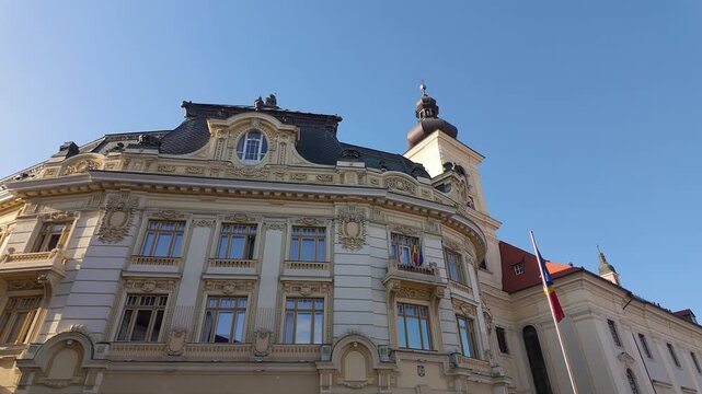 Ornate Sibiu City Hall facade beside Holy Trinity Roman Catholic Church in Piata Mare Romania
