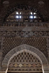 Ornate brickwork interior of the Samanid Mausoleum in Bukhara showing geometric patterns and corbelled arches. Ideal for architecture, heritage, and travel publications. © finepoints