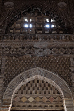 Ornate brickwork interior of the Samanid Mausoleum in Bukhara showing geometric patterns and corbelled arches. Ideal for architecture, heritage, and travel publications.