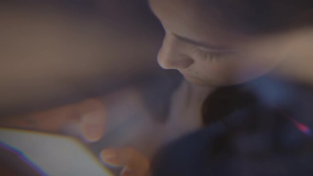 Young adult Caucasian woman using smartphone in dark room, scrolling screen with double exposure effect. Footage represents digital burnout, screen addiction, or mental health awareness campaigns