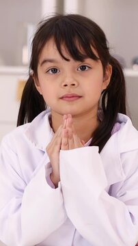 Young Girl in Lab Coat Holding Hands Together in Prayer
