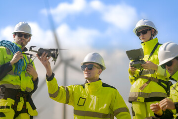 Fototapeta premium Bearded technician at the left of frame steadies a quadcopter while the fair haired pilot beside him reaches up and a blonde colleague holds the controller at the right