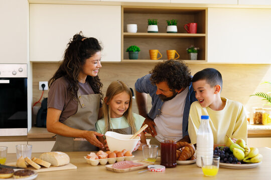 Family enjoying a morning bonding activity, preparing breakfast at home with children learning from parents, creating a warm and cheerful domestic scene