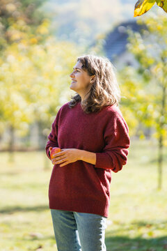 Woman with ripe apple in an autumn park