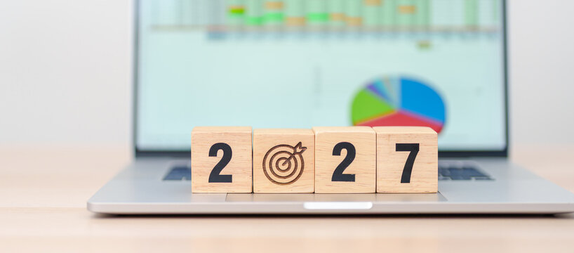 Happy New Year 2027 block with dartboard icon against computer laptop background. Goal, Target, Resolution, strategy, plan, Action, mission, motivation, and New Year start concepts