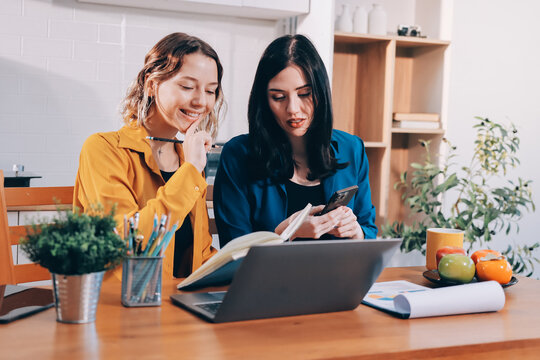 Portrait of military mother helping teen daughter with homework and eating lunch