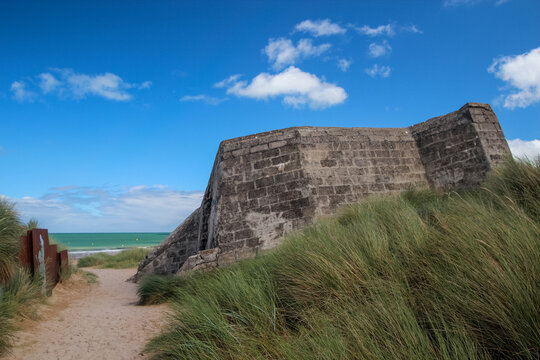 World War II concrete bunker structure nestled in coastal sand dunes at Juno Beach Normandy
