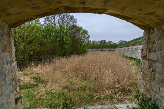 View through a stone embrasure over the dry moat of a historic fortress, Hungary