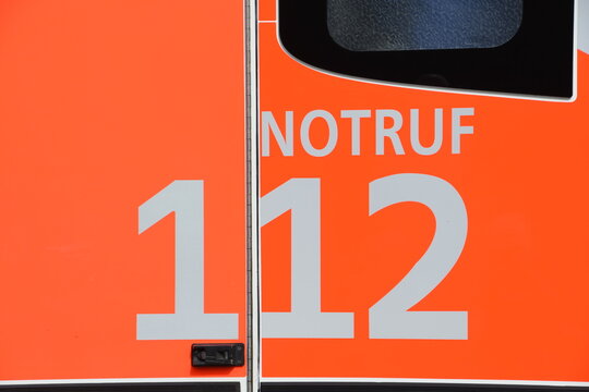Aufschrift "Notruf 112" f&uuml;r Feuerwehr auf neonrotem Fahrzeughintergrund