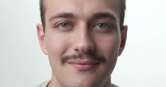 Extreme Close-up of Young Man Smiling at Camera on White Background