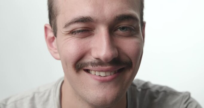 Extreme Close-up of Young Man Smiling directly at Camera on White Background