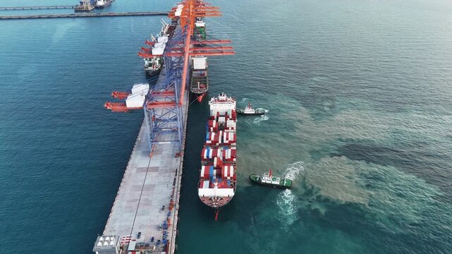 Container ship maneuvering at sea port terminal assisted by tugboats. Heavy cargo vessel docking for freight. Global maritime logistics, international shipping trade, and marine transport.