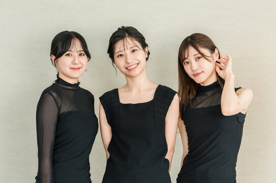 黒のファッションで上品に微笑む女性3人のビューティーポートレート