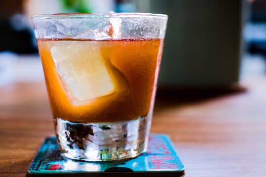 Orange cocktail with large rectangular ice cube in old fashioned tumbler