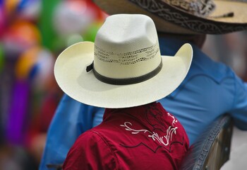 Naklejka premium Native young boy wearing an authentic Mexican straw sombrero hat in the historic center of San Miguel de Allende, Guanajuato Mexico.