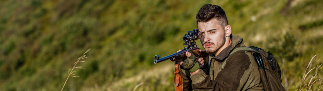 Shooter sighting in the target. The man is on the hunt. Hunt hunting rifle. Hunter man. Hunting period. Male with a gun. Close up. Hunter with hunting gun and hunting form to hunt. Hunter is aiming